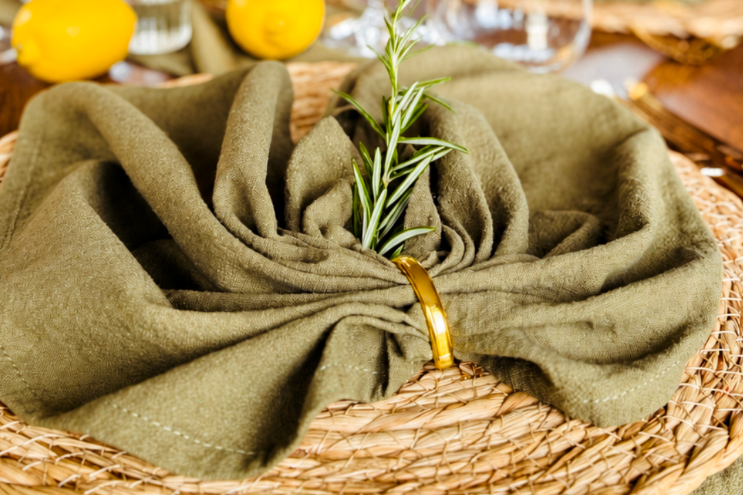 Hochzeitsdeko mieten Tischgedeck mit Tellern, Besteck und gefalteter Serviette auf einem eleganten Tisch.